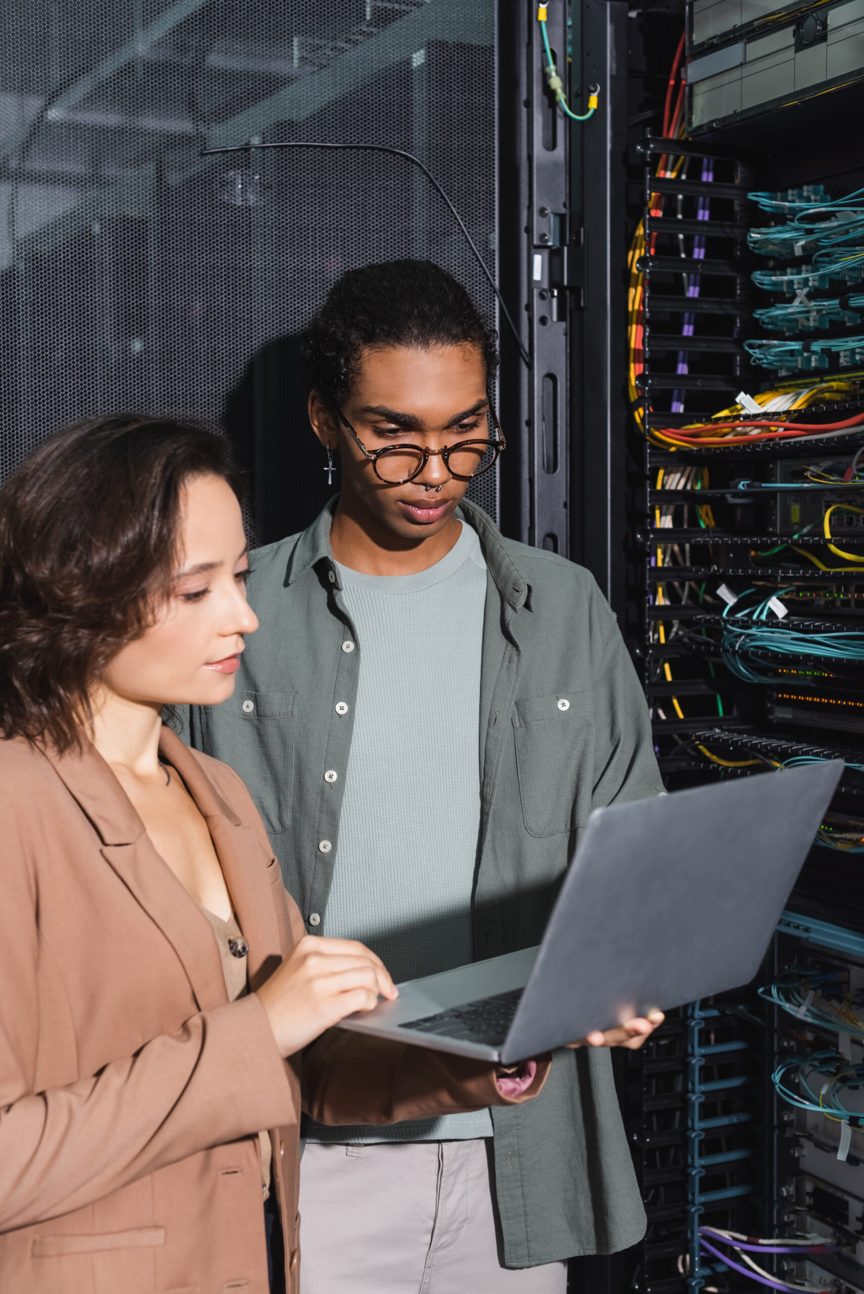 multiethnic technicians working on laptop near server in data center Managed IT Service Provider