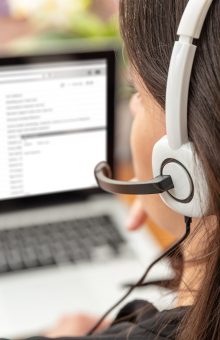 Home office, customer support, help desk concept. Woman with headset work on a laptop Managed IT Service Provider