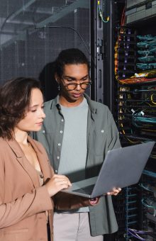 multiethnic technicians working on laptop near server in data center Managed IT Service Provider